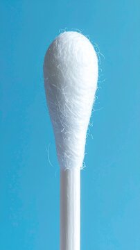 Macro Shot of a White Cotton Swab Tip Over a Blue Background