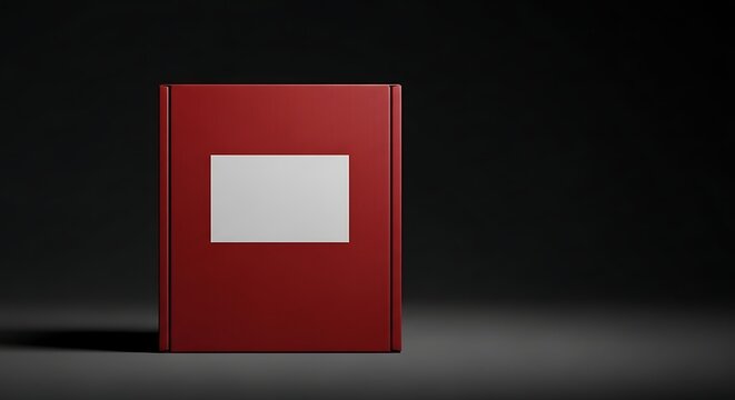 A closed, plain red book with a white label on its cover, set against a dark, moody background.