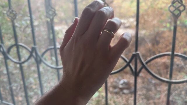 Close-up of fingers gently tapping on window glass