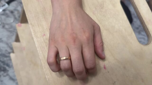 Fingers rhythmically tapping on a wooden surface