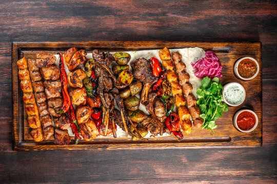Mixed grilled meat platter with vegetables and sauces