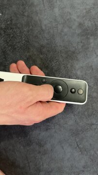 Close up of remote control in hand on sofa, home technology concept showing digital device use, comfort and everyday indoor lifestyle