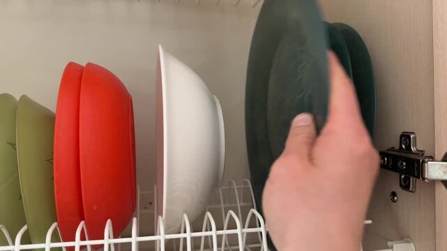 Hand placing plate into dish drying rack