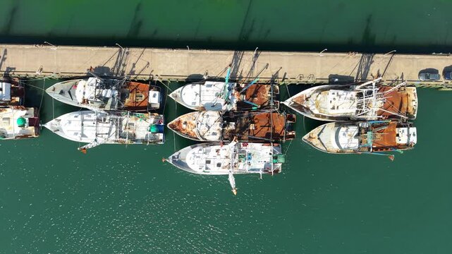 Aerial view of commercial fishing trawlers and scalloping boats docked at a concrete pier in Newport News, Virginia