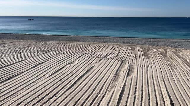 Beach's Pattern by Sea: A mesmerizing view of patterned sand against the backdrop of the serene blue sea, evoking a sense of tranquility.