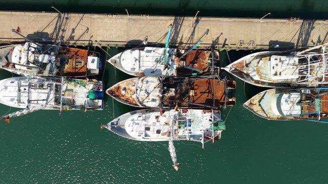 Aerial view of commercial fishing trawlers and scalloping boats docked at a concrete pier in Newport News, Virginia