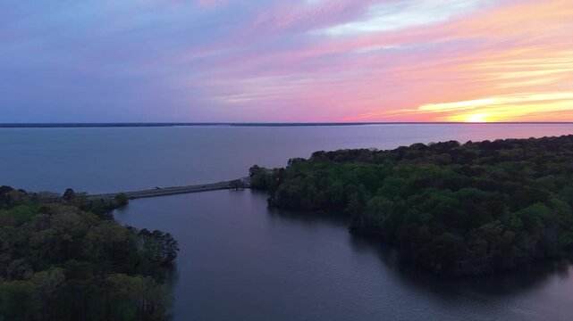 James River coastline in Newport News, Virginia, aerial sunset video, featuring luxury waterfront residential homes and a vibrant evening sky. 