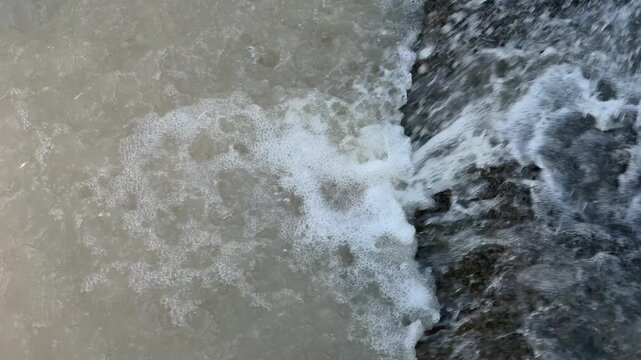River water flowing along concrete edge outdoors