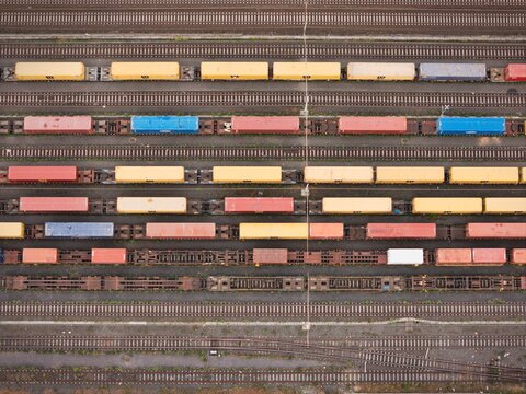 Santo Stefano di Magra, Italy - 18 April 2026: Aerial view of Retroporto merci freight terminal with colorful shipping containers on parallel railway tracks under soft daylight.