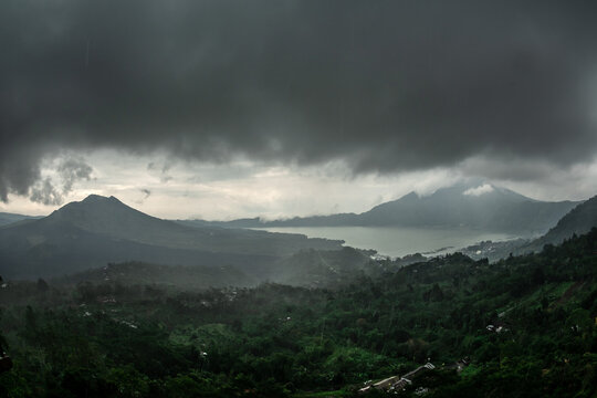 Mount Batur volcanic landscape with lake and storm clouds over Mount Abang Bali