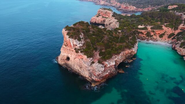 Turquoise water gently laps against the rocky coastline and sandy beach of calo des moro in mallorca, spain