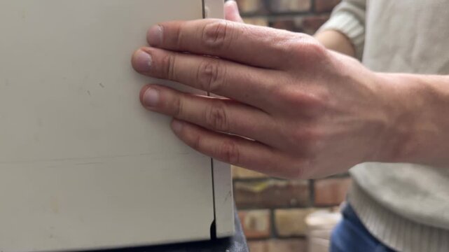 Person opening and closing the front tray of a home printer. Close up of hands operating paper feed compartment of office printing device. Everyday document printing and office equipment concept