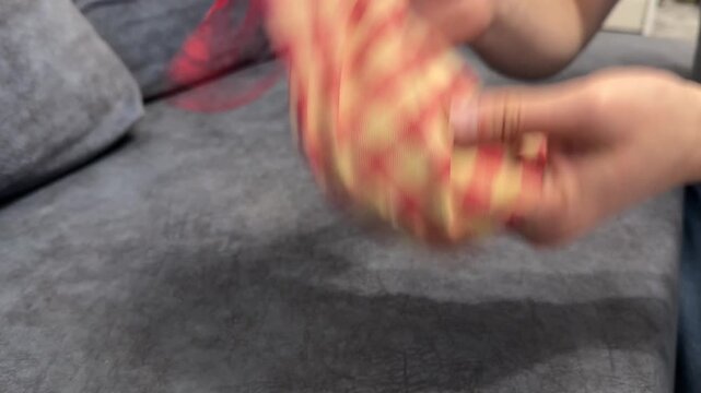 Hands shaking a small fabric bag with game pieces inside. Close up of mixing lottery tokens or lotto game pieces before drawing. Board game preparation and random selection concept