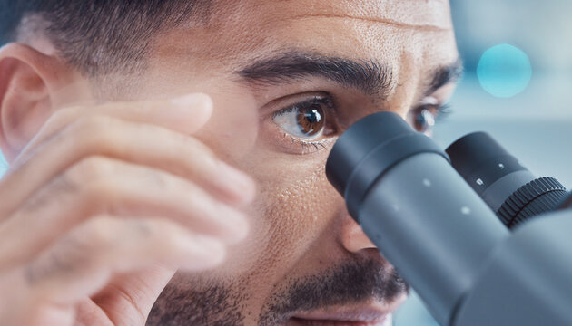Biologist looks through microscope in laboratory during research on specimens and samples