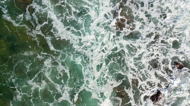 Cinematic aerial drone footage of the Normandy coastline in France, featuring ocean waves crashing against rocky cliffs along the English Channel. Natural coastal landscape captured from above, ideal 