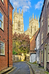 View through the Old Town streets of York, England with brick houses and the the beautiful facade of York Minster © Jenifoto