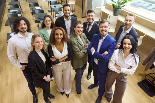 Business team professionals pose together showing teamwork. Diverse group in office smiles, showing leadership, diversity and collaboration for marketing and hiring. Clear teamwork success concept.