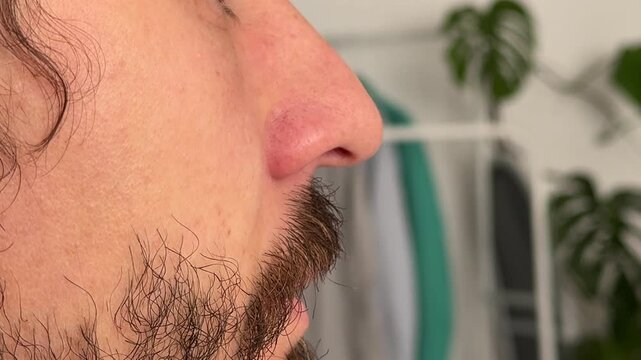 Close-up profile of a man with nostrils flaring. Subtle facial motion linked to emotion, breath, or alertness