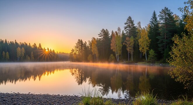 A calm lake at sunrise with mist rising from the water. The sun is low behind a pine forest, creating a orange glow. The water is still like a mirror, reflecting the trees and the morning sky