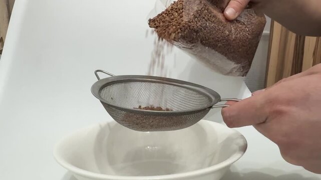 Pouring buckwheat into a strainer