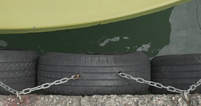Boat Hull Impacting Rubber Tire Fenders on Pier