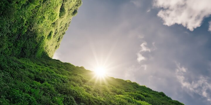 Sunlight breaking over moss covered cliff with cloudy sky