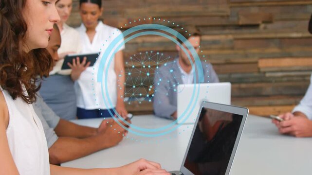 Vertical video: Woman typing on laptop and starting blue HUD overlay while team working in business