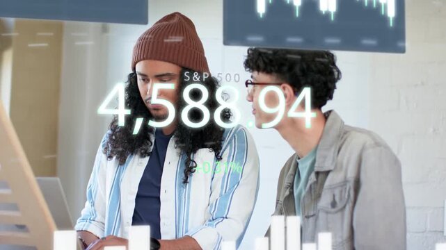 Coworkers typing and leaning at workstation, watching S and P 500 overlay rising bar graphs for fina