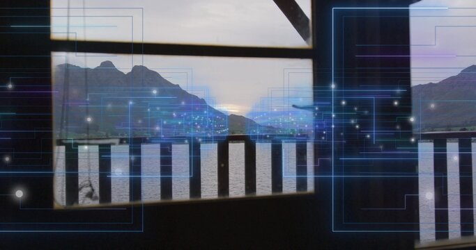 Framing balcony railing and window frame, showing lake and mountains at dusk with blue overlay