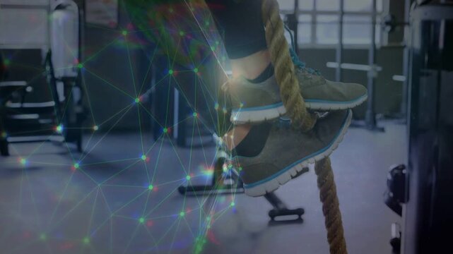 Woman gripping rope and alternating foot hooks, ascending for fitness while network overlay growing