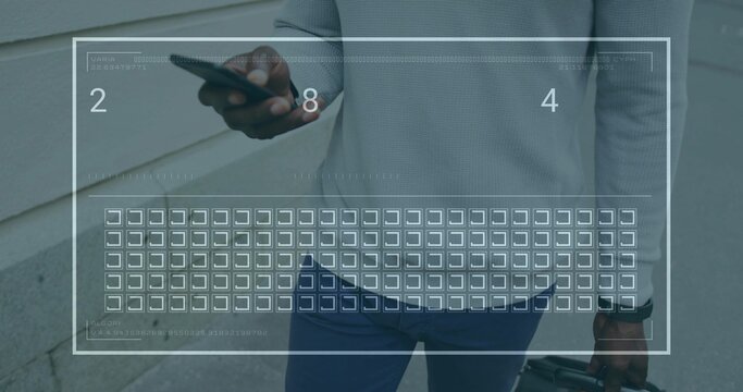 Walking man in gray sweater navy pants beside paved path, holding phone, carry-on with grid overlay