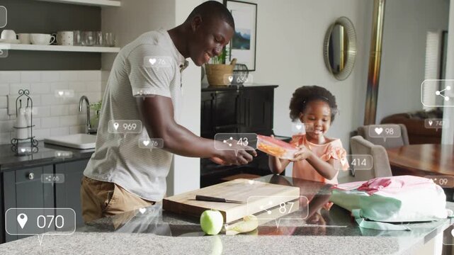 Father handing food container, daughter packing school lunch on island, overlay icons floating