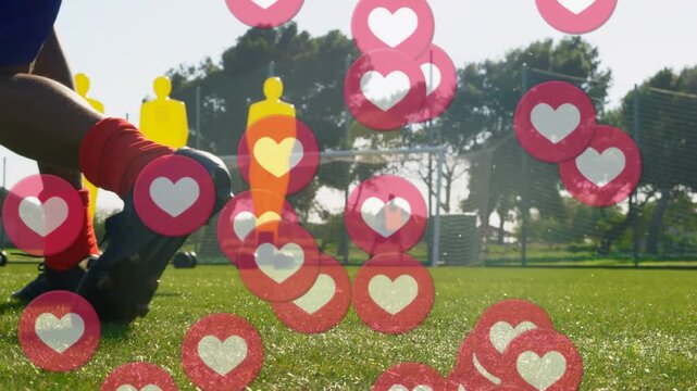 Player planting foot, striking soccer ball in sports drill, hearts floating, partly obscuring frame