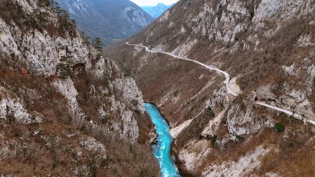 Aerial view of winding mountain road above Piva river. High angle shot of serpentine asphalt road on cliff side next to turquoise river in Piva canyon, Montenegro.