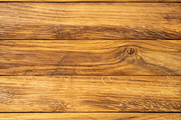 Fototapeta premium Close-up view of natural wooden planks with rich grain texture. The warm tones and intricate details make it suitable for interior design, backgrounds, and creative projects.