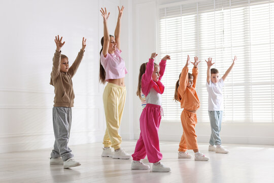 Professional dance teacher training children in studio
