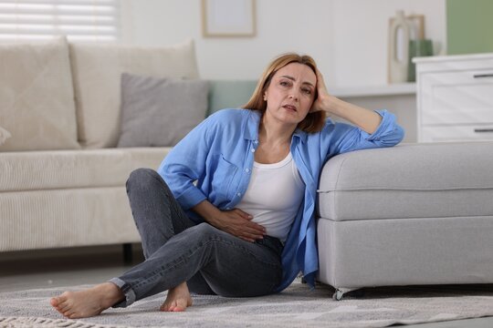 Menopause. Woman suffering from abdominal pain at home