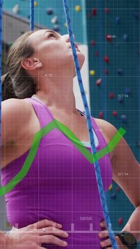 Vertical video: Climber eyeing route pulling rope into belay securing climb, green chart overlay