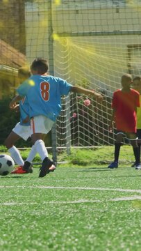 Vertical video: Soccer striker getting ball, dribbling, trying to score, keeper diving, saving ball