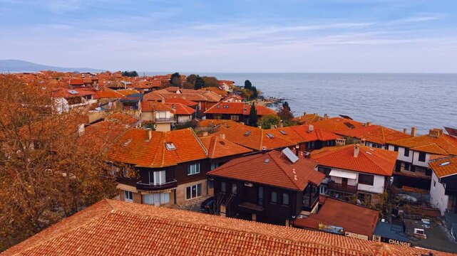 Footage over the red-tiled roofs of the houses on the seashore. Villas on the coast of Nesebar, Bulgaria.