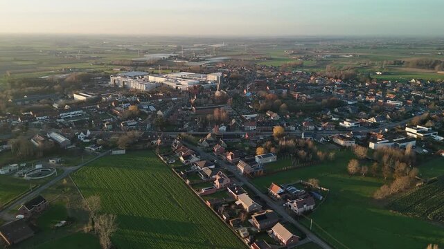 Aerial panoramic of Westrozebeke, Belgium. Large-scale industrial plants dominate the skyline of this historic village, blending modern production with ancient Flemish battlegrounds.