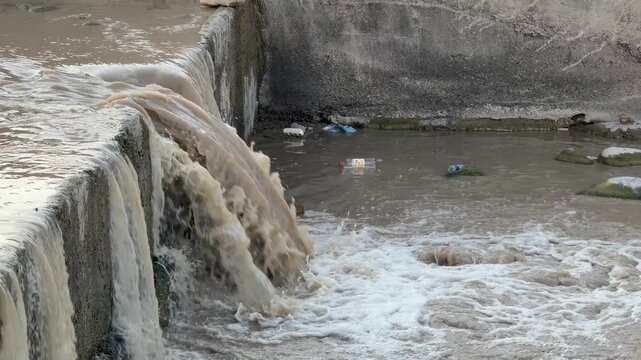 Waterfall flowing over concrete dam wall