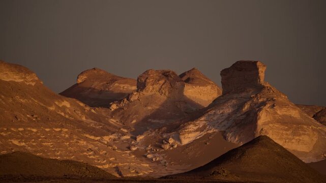 Limestone hills in Egypt&rsquo;s White Desert at sunrise. Single shot of large limestone hills in Egypt&rsquo;s White Desert, bathed in warm yellow light of early morning. 