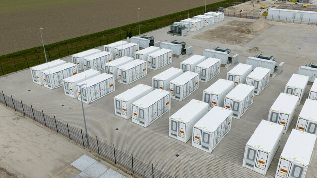 Dronten, Netherlands - 04 April 2026: Aerial view of the Olsterdwarspad battery energy storage system facility with rows of white containers and electrical infrastructure.
