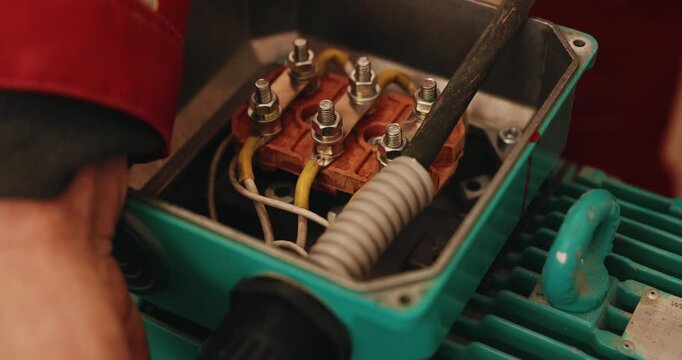 Connecting electrical wires in pump junction box during installation close up