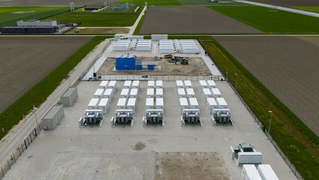 Dronten, Netherlands - 04 April 2026: Aerial view of the Giga Storage battery facility at Olsterdwarspad with rows of white containers and transformers surrounded by green fields.