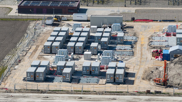 Espel, Netherlands - 04 April 2026: Aerial view of the Hoogspanningsstation - Westermeerdijk battery storage facility under construction with rows of grey units and heavy machinery.