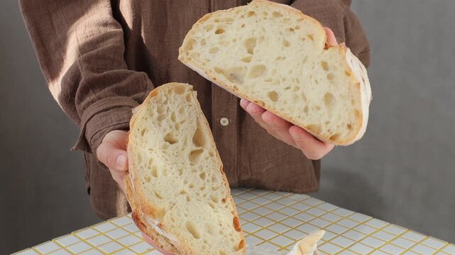 person is holding white bread in hands. homemade sourdough bread with crispy crust. Bakery products. yeast-free sourdough bread. healthy and healthy food. bakery. health care, gluten-free farm flour.