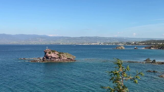 Rock of Gabor with cross above Aphrodite beach in Cyprus Akamas with blue sea, ideal for tourism and cultural travel marketing. Coastal landscape highlights history and Mediterranean destination. 