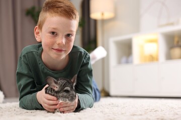 Obraz premium Child with his cute chinchilla on floor at home, space for text. Adorable pet